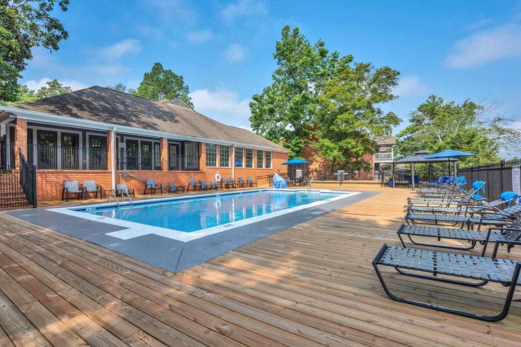 a swimming pool with chairs around it outside of a building